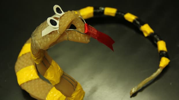 Cobra-resembled, fake snake, made of gelatin, wire, and tape; has stripes color of yellow and black, used for art accesories.