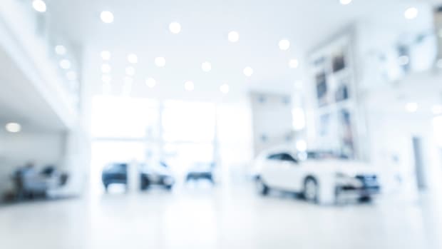 Blurred abstract dealership store, with defocused cars, clients and staff with soft lightning